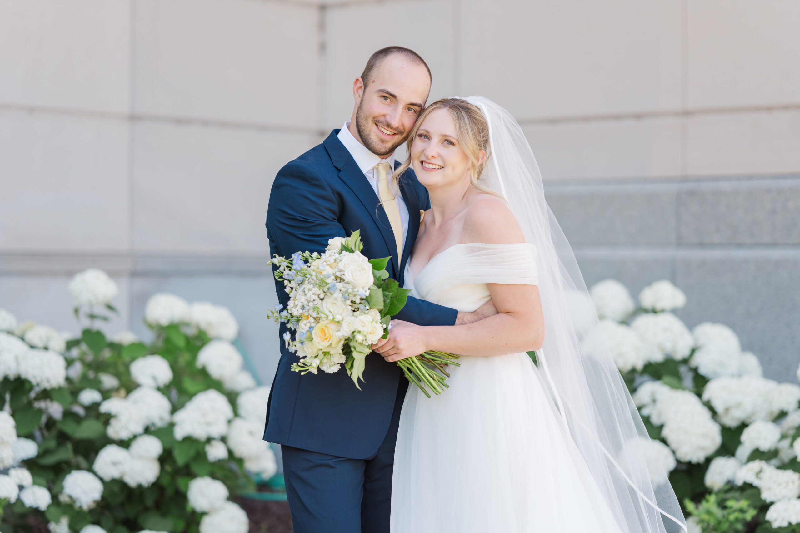 a bride and groom hug one another and smile for the camera